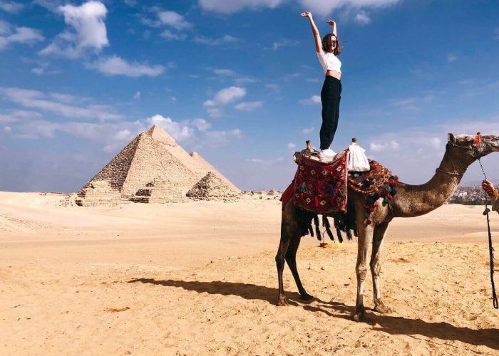 great-shot-of-a-female-tourist-standing-on-a-camel